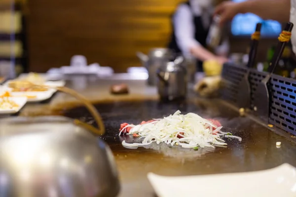 데파냐 요리사가 뜨거운 금속판에 음식을 — 스톡 사진