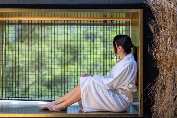 女性は外の美しい木と窓の横に座る — ストック写真