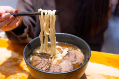 Kadınlar lokantada etli eriştenin tadını çıkarırlar. 