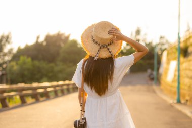 Gezgin kadın, gün batımında manzaranın tadını çıkar.