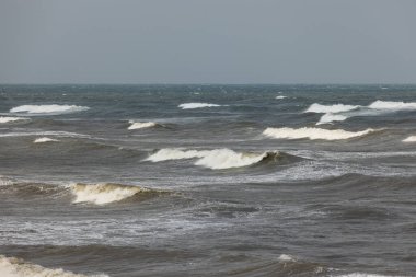 Büyük deniz dalgaları kıyı şeridine çarpıyor.