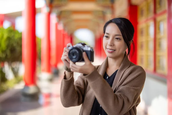 旅行の女性は中国の寺院で写真を撮るためにデジタルカメラを使用します — ストック写真