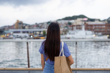 Tayvan 'ın Keelung şehrinde denize bakan turist kadın