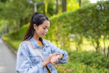 Kadınlar parkta akıllı saat kullanır.