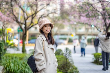 Kadın kameraya kışın giydiği kıyafetlerle gülümsüyor