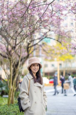 Şehrin arka planında kameraya gülümseyen kadın