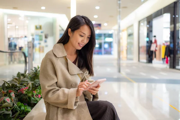stock image Woman use smart phone and sit inside shopping mall
