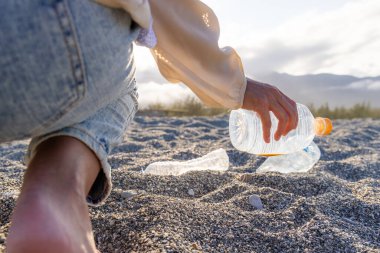 Temiz plaj konsepti gönüllüsü. Plajdaki çöpleri topla.