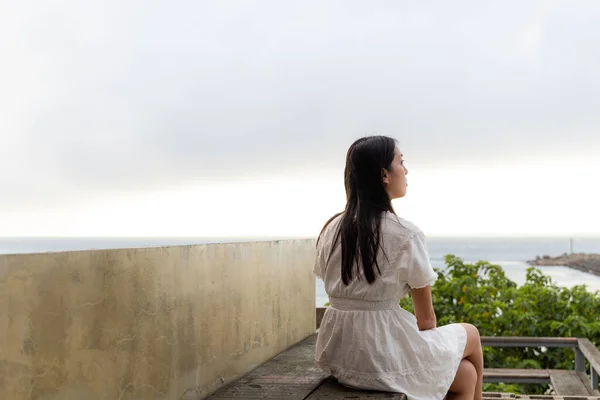 Kadın Dışarıda Oturup Deniz Manzarasının Tadını Çıkar — Stok fotoğraf