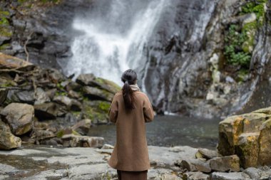 Turist kadın, Tayvan 'ın Yilan kentindeki Wufengqi şelalesine yürüyüşe gitti.