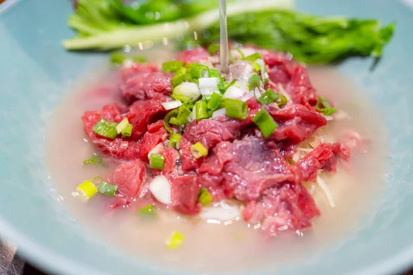 烧热的热汤倒入面条和一片生牛肉 是台湾金门的名菜 — 图库照片