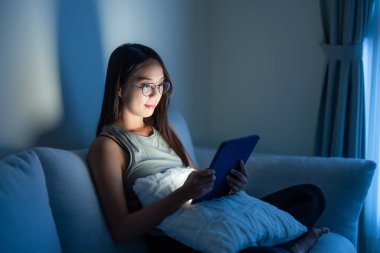 Kadın dijital tablet bilgisayarda gözlüklü okuyor