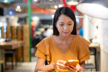 Kadınlar restoranda akıllı telefon kullanır.