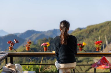 Turist kadın kahve dükkanının manzarasının tadını çıkarıyor. 