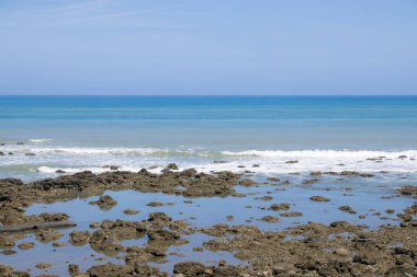 Mavi gökyüzü ile deniz kayalıkları