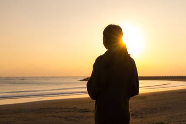 Silhouette of woman enjoy the sunset in the beach