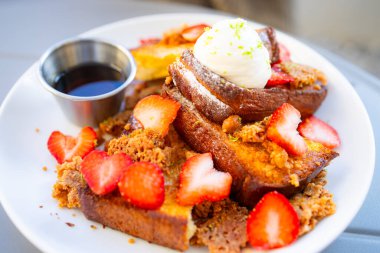 Toast with cream, strawberry and syrup