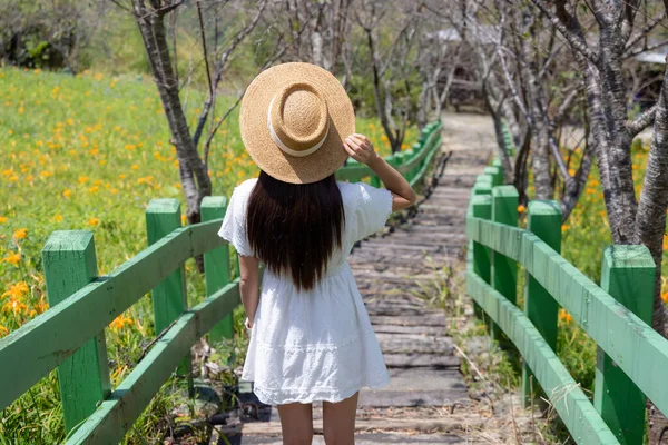 Beyaz elbiseli bir turist ve ormanda bir basamak boyunca yürüyor.