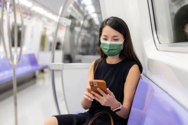 Tayvan metrosunda kadın yüz maskesi takıyor.