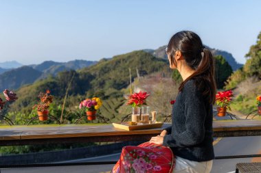 Turist kadın kahve dükkanının manzarasının tadını çıkarıyor. 