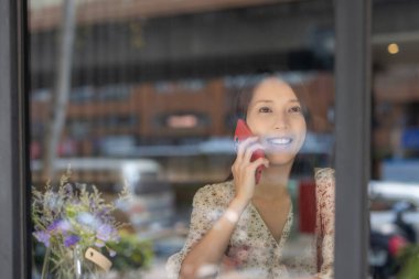 Kadın kahveciden telefon alıyor.