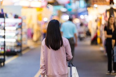 Turist kadın geceleyin Tayvan 'da markete gidiyor.