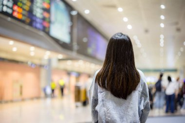 Seyahat eden kadın, ekrandaki uçuş çizelgesine bak.