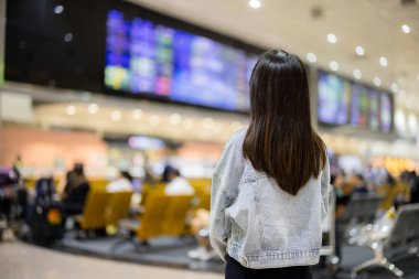 Seyahat eden kadın, ekrandaki uçuş çizelgesine bak.