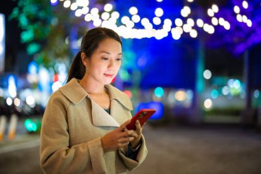 kadın gece şehirde cep telefonu kullanmak