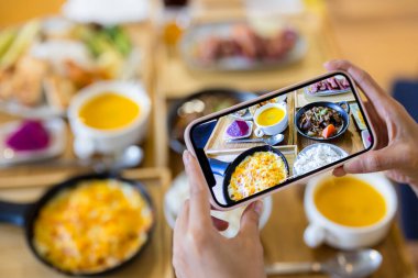 Yemeğin üzerinde cep telefonuyla fotoğraf çek.