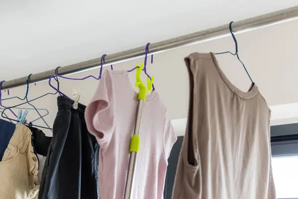 乾燥した洗濯物の服および屋内で掛かる — ストック写真
