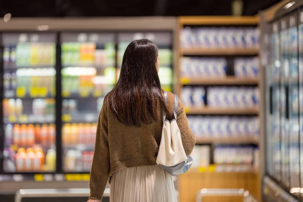Woman go shopping in supermarket buying groceries