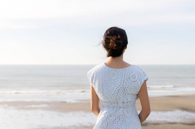Kadınlar kumsalın tepesindeki manzaranın tadını çıkarırlar.