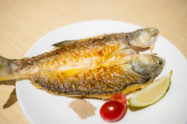 Beyaz tabakta ızgara balığı.