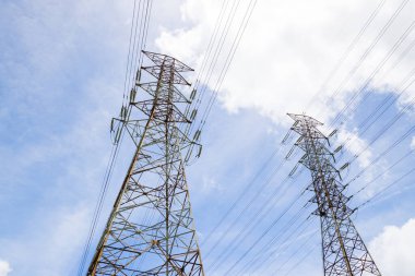 Elektrik hatları ve pilonlar mavi gökyüzüne karşı