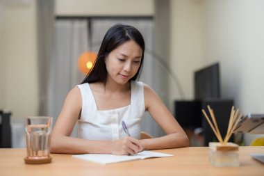 Ev hanımı evdeki deftere yazıyor.