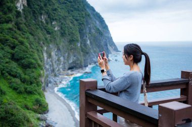 Hualien Denizi 'nde bir kadın cep telefonu kullanıyor.