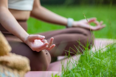 Kadın parkta meditasyon yapıyor.