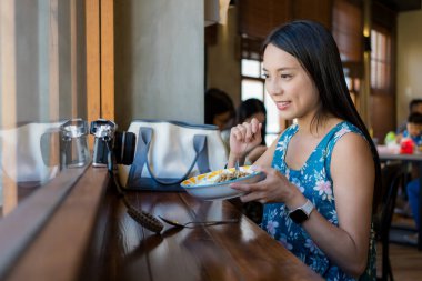 Kadın lokantadaki kameraya video çekiyor.