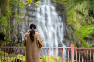 Kadın, Tayvan 'daki Wufengqi şelalesine bak.
