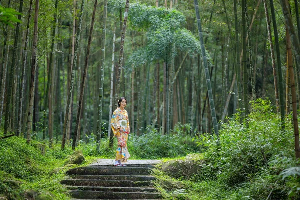 Bambu ormanında kadınlar kimono giyer.