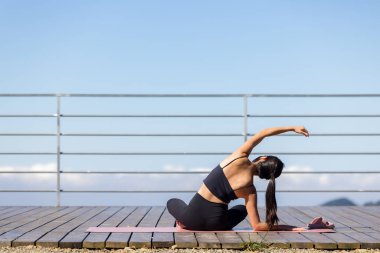 Kadın dağda yoga egzersizi yapıyor.