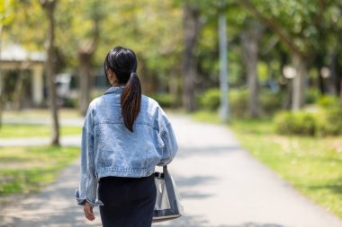 Yeşil parkta yürüyen bir kadın