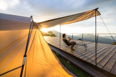 Kadınlar kampa gider ve gün batımında atıştırmalıklarla dışarıda otururlar.