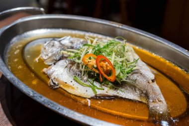 Yeşil soğan ve soya soslu haşlanmış balık.