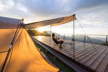 Kadınlar kampa gider ve gün batımında atıştırmalıklarla dışarıda otururlar.