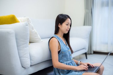Kadın evde dizüstü bilgisayar kullanıyor