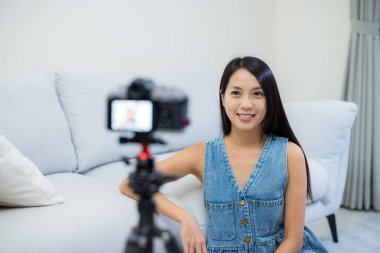 Kadın evde video günlüğü almak için dijital kamera kullanıyor