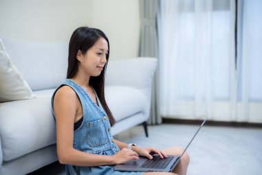 Kadın evde dizüstü bilgisayar kullanıyor