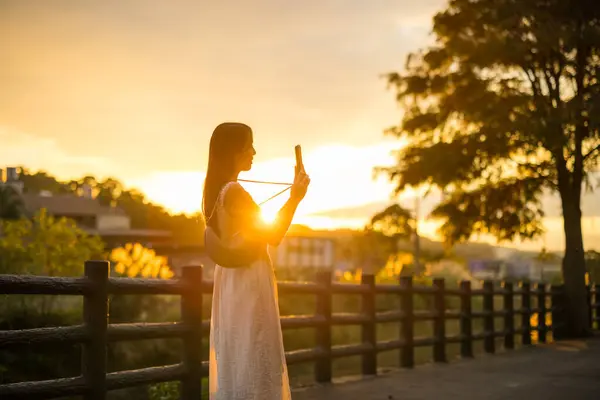 Žena Použít Mobilní Telefon Fotit Při Západu Slunce — Stock fotografie